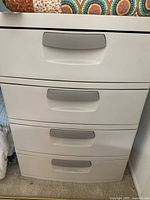 Frontal view of the Sterlite four-drawer plastic storage cabinet in taupe showing four drawers with gray handles.