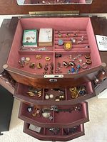 Top tray of jewelry box showing velvet ring rolls with 11 rings and scattered earrings