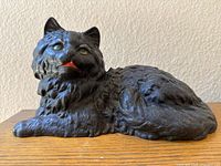 Side view of cast iron cat doorstop showing the lying pose and fur texture