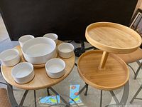 Photo showing the Lazy Susan with the six small white ceramic bowls and one large ceramic bowl on the rotating wooden base next to the two-tiered wooden serving tray.