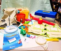 Image of two fishing play sets including tackle boxes, vests, nets, fish, worms, poles, bucket, and fishing activity booklet.