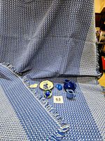 Full view of the blue and white mountain weave cotton tablecloth with all included items placed on or near it.