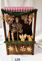 Front view of Byers Choice Christmas market stall with hanging straw ornaments and wooden tree back panel