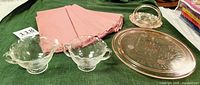 Overall group photo showing pink Jeannette Glass footed cake plate, Westmoreland Woolworth candy dish, Hazel Atlas sugar and cream set, and pink cloth napkins.