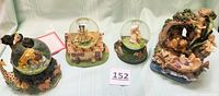 Four vintage Disney musical snow globes from the Heroines of the Forest collection displayed together on a table, showing each unique themed base and globe.