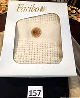 Faribo wool throw in original white packaging with brand name visible, folded to show texture and embroidery design.