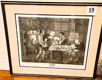 Framed black and white engraved print showing detailed scene of an attorney with clients in an interior with papers and coins