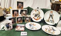 Photo showing six vintage Norman Rockwell mugs in original boxes and one unboxed mug, alongside four 8-inch diameter collector plates with gold accents.