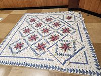 Full view of the 86 x 84-inch star quilt laid out flat on the floor with two matching envelope-style shams placed on top.