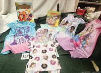 Lot showing four Disney princess nightgowns, pajama set, and two children's books arranged with visible Disney princess designs and colorful covers.