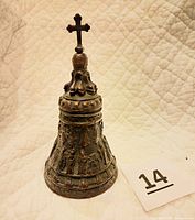 Front view of the full bell showing cross on top and detailed relief work.