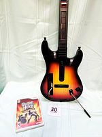 Front view of the Guitar Hero World Tour Wii guitar controller with game case on white background.
