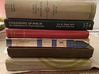 Stacked antique books showing spines with titles and wear.