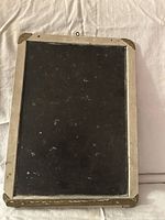 Front view of the antique slate chalkboard showing slate surface and wooden frame with chalk ledge