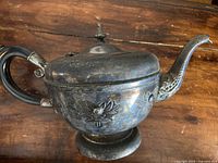 Antique Viking Plate teapot with floral embossed design and black handle, showing patina and aging