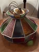 Side view showing multicolored stained glass panels and brass fitting on top