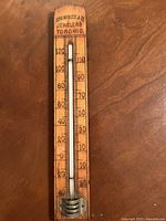 Front view of antique wooden thermometer with clear temperature scale from -40 to 120 Fahrenheit and brand text John Wanless & Co Jewelers Toronto at the top.