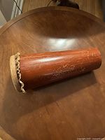 Full view of the Ashiko drum showing the wooden conical body with visible scratches and finish wear.