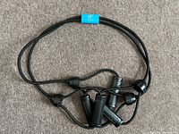 Resistance bands laid out on gray carpet showing multiple handles connected to black elastic bands.