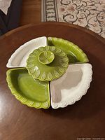 Top view of the round ceramic chip and dip Lazy Susan showing four divided sections in alternating green and white with central avocado green covered bowl.