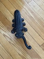 Top view of antique cast iron cricket boot jack showing detailed insect design with textured wings and legs.