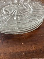 Stacked view of 5 clear glass plates showing thickness and rim detailing.