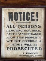 Front view of the entire framed antique land notice showing the text and overall condition.