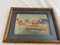 Frontal photo of the framed wood cork carving showing the Japanese landscape scene.