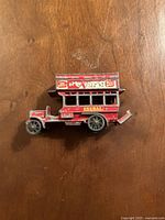 Side view of vintage red Matchbox Lesney General double-decker bus toy showing detailed advertising and worn paint.