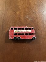 Top view of red London trolley bus model showing advertising decal and paint wear