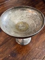 Top-down view of silver champagne coupe showing interior surface wear and tarnish.