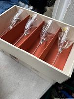 Photo of 5 crystal wine glasses in orange box sections inside original packaging showing etched crystal cut design.