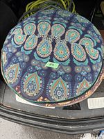 Top view of the floor cushion showing colorful paisley and floral pattern on a dark blue background.