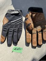 Photo of a pair of gloves, right glove black fabric with gel impact protection and firm grip branding, left glove brown leather worn, size large.
