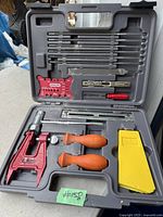 Open Oregon chainsaw sharpening kit showing contents with files, file handles, file guide, depth gauge tool, and accessories in gray plastic case.
