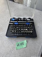 Open view of precision screwdriver set showing screwdriver handle, extension, and 32 bits arranged on tray with size labeling.