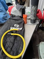 Rolled paddle board, pump, carrying bag and fin displayed on table