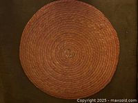 Rust color round placemat with woven texture and concentric circular pattern shown flat on a surface.