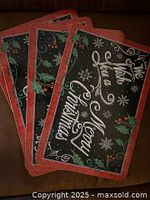 Four rectangular wooden placemats themed for Christmas with message and holly decoration.