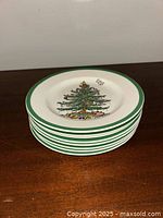 Stack of 8 appetizer plates with a Christmas tree design and green rim