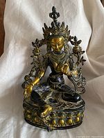 Full front view of seated Green Tara statue on lotus base