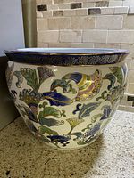 Front angle view showing overall shape, floral decoration and cobalt blue rim.