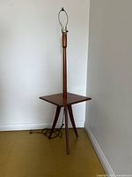 Full view of lamp and side table against wall