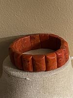 Front view of vintage red coral bracelet showing rectangular beads and elastic cord.