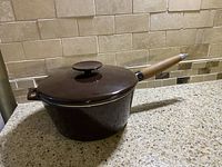 Side view of vintage brown enamel Copco saucepan with lid on a kitchen counter.