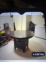 Photo of the round dining table fully assembled in a room showing overall shape and base design.