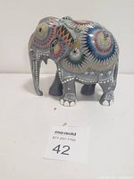 Photo of decorative painted Africa elephant figurine from side view showing detailed colorful patterns.