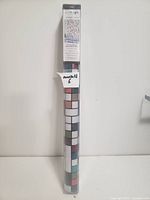 Window film roll in its original packaging showing mosaic stained glass pattern design.