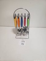 Cutlery set displayed on chrome stand showing colorful handles and utensil types