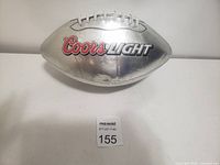 Single silver Coors Light football with visible logo on white background.